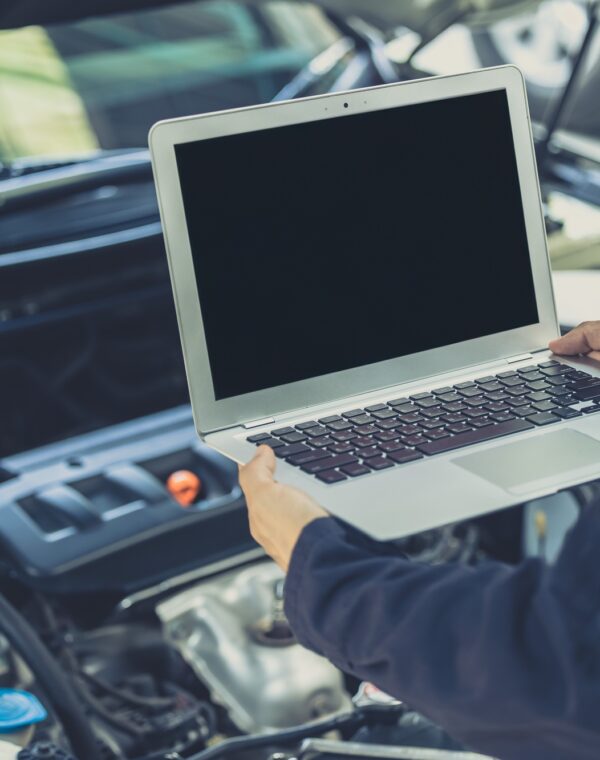 laptop computer blank screen with modern car engine performance ECU tune up in auto garage workshop